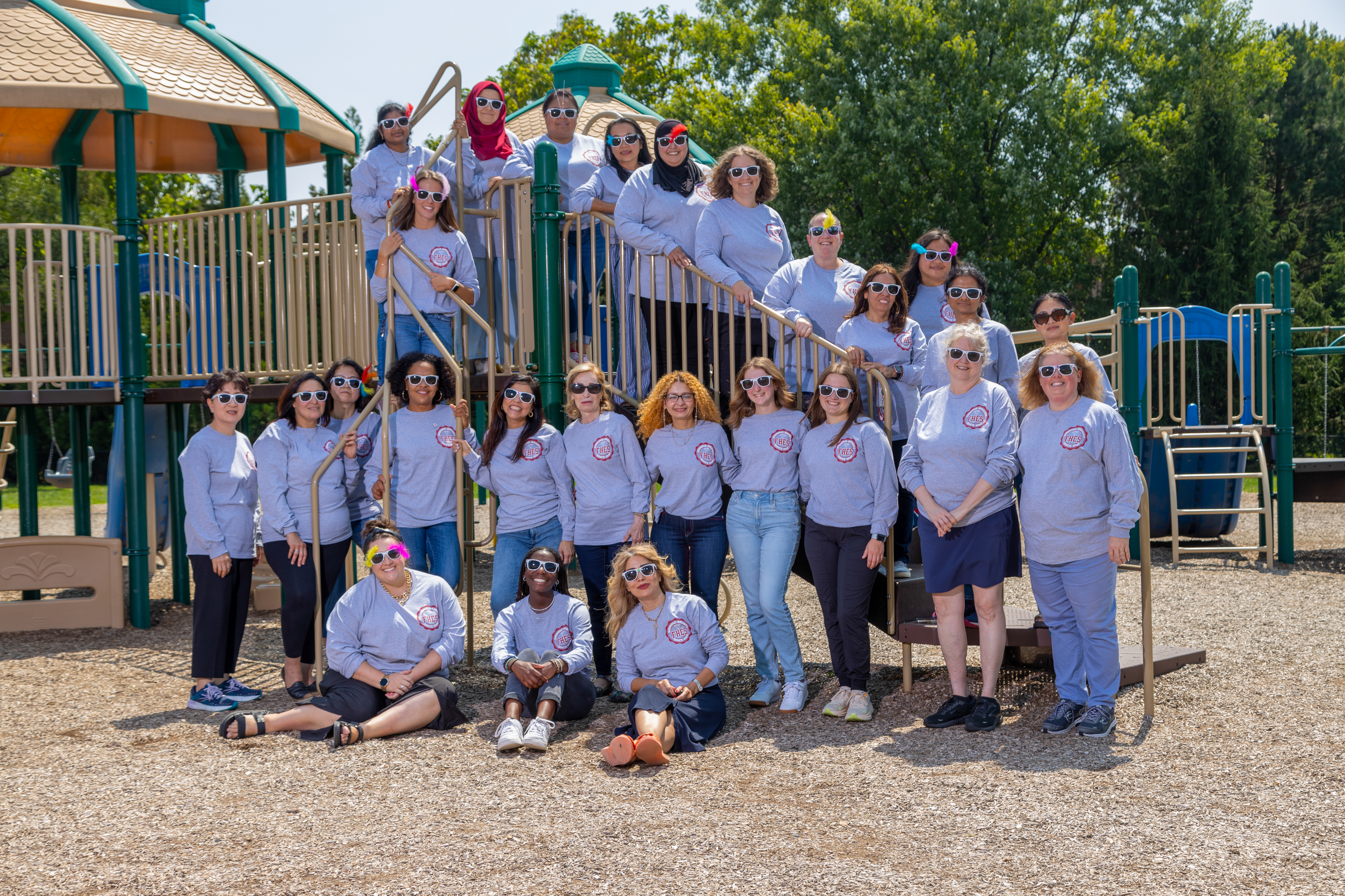 staff smiling on playground equipment